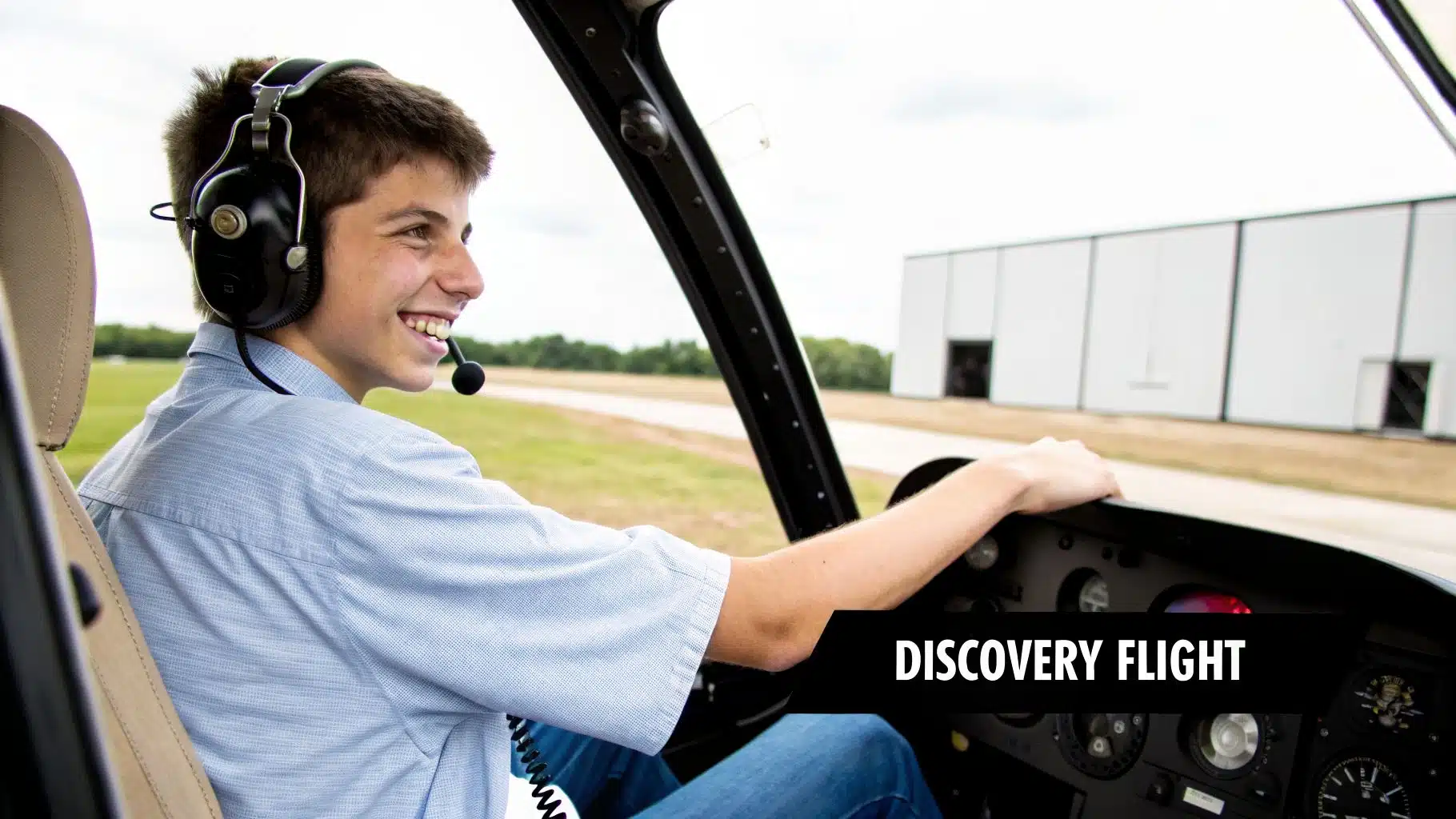 Your Guide to a Helicopter Discovery Flight Near Me 2 Smiling young man in a helicopter cockpit wearing a headset during a discovery flight.