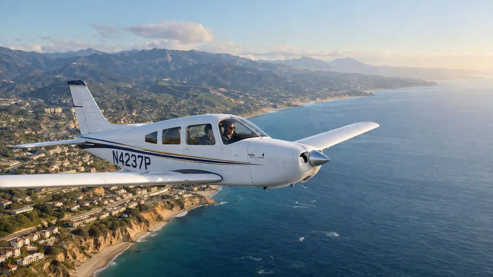 Piper Archer Rental Near Me: Your Guide to KCNO Flying 4 A Piper Archer airplane flying over the scenic California coastline during a beautiful sunny afternoon.