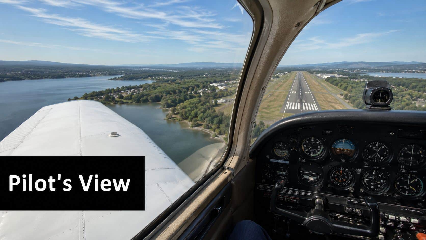 What Is Angle of Incidence? a Pilot's Guide to Performance 4 A pilot's perspective inside a small airplane cockpit looking down at a runway near a lake.