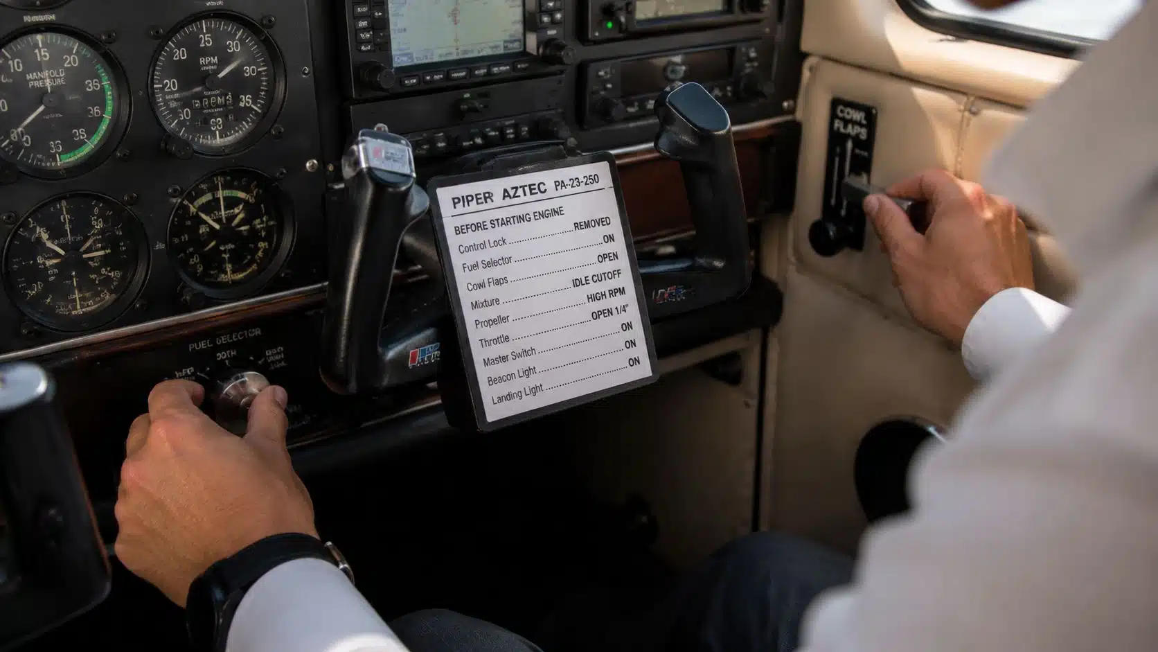 Piper Aztec Rental: A Pilot's Guide to Training and Checkout 4 A pilot inside a Piper Aztec aircraft cockpit operating the fuel selector and cowl flaps controls.
