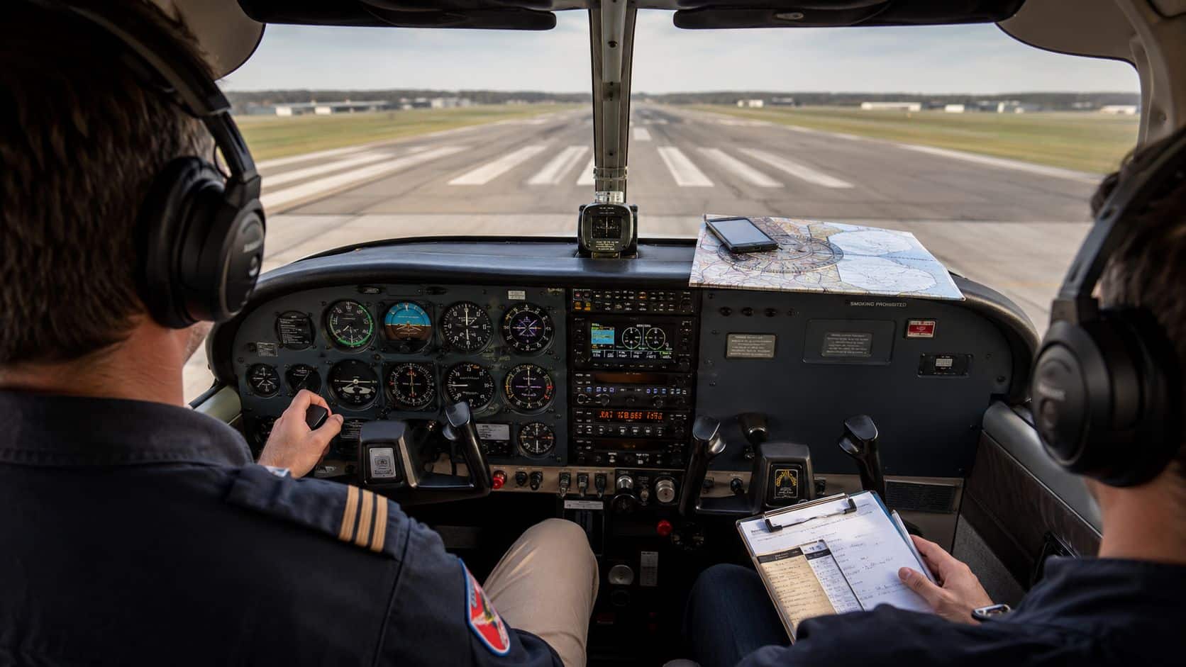 Private Pilot Training Costs: A Transparent Breakdown 4 Two pilots in an aircraft cockpit preparing for takeoff on a sunny airport runway.
