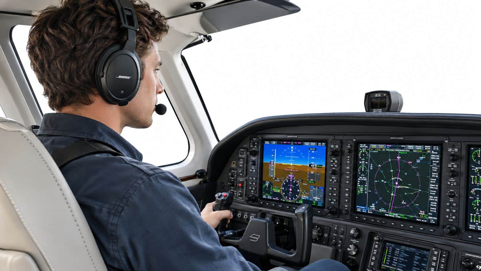 Accelerated IFR Training: Your Complete Guide 2 A pilot wearing a headset sits in an aircraft cockpit, monitoring the digital flight instrument displays.