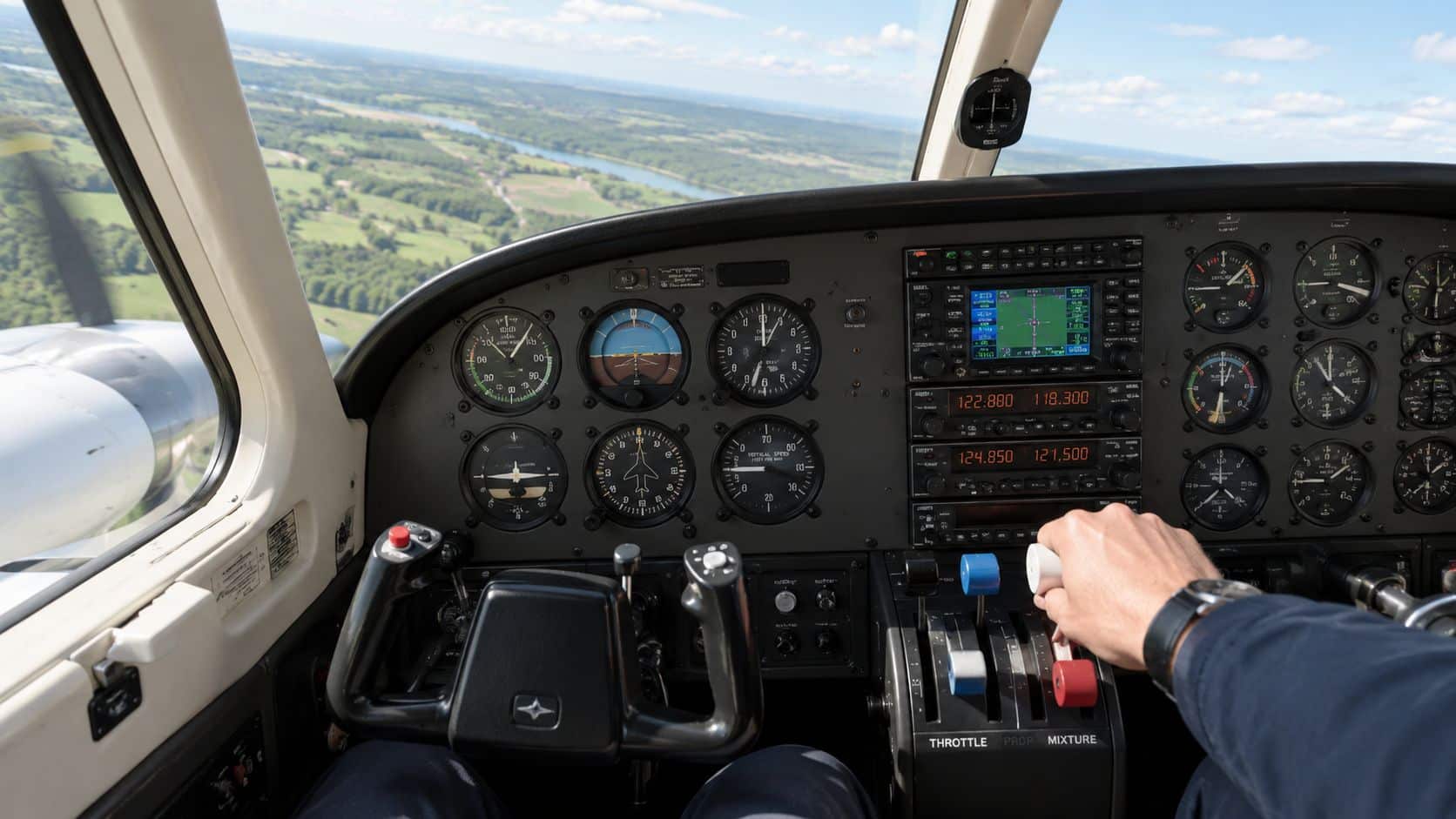 Multi Engine Ratings Explained for Pilots 2 A view from the cockpit of a twin engine airplane as the pilot operates the throttle controls.