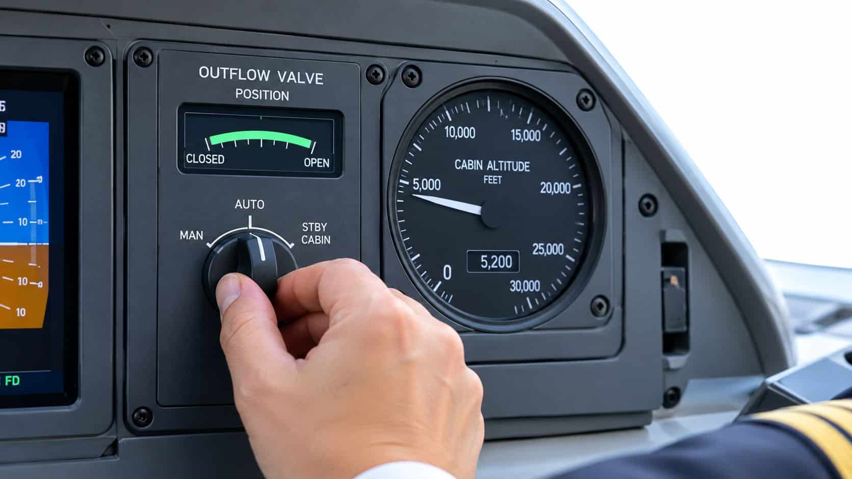 Pressurization System: A Pilot's Complete Guide 3 A pilot's hand adjusting the pressurization system dial on an airplane control panel in the cockpit.